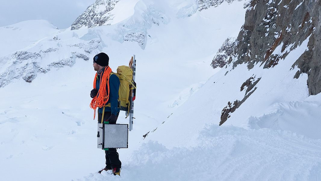 Mit Seil, Säge und Koffer: Lars Mewes, Schneephysiker am SLF, auf dem Weg zur Arbeit am Jungfraujoch. (Foto: Lars Mewes / SLF)